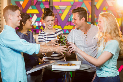 Group of friends toasting bottle of beer