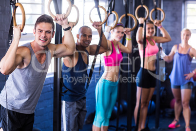 Portrait of smiling people with gymnastic rings