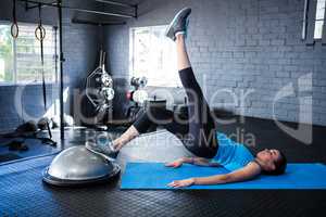 Full length of female athlete with BOSU ball in gym