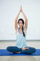 Woman sitting in lotus pose with eyes closed