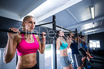 Athletes doing chin-ups in gym