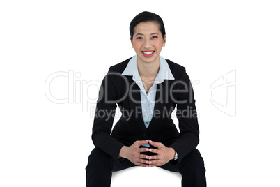 Confidence businesswoman sitting against white background