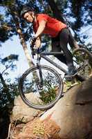 Male mountain biker riding bicycle in the forest