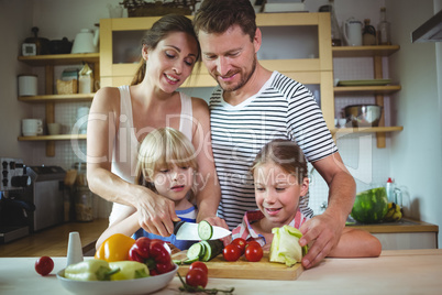 Family chopping vegetables in the kitchen