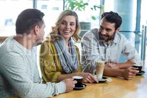 Friends interacting while have a cup of coffee