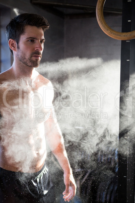 Male athlete standing by chalk dust