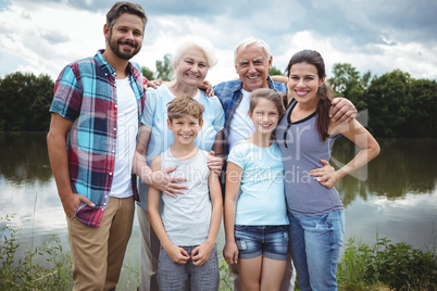 Happy multi-generation family standing near a river