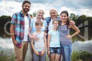 Happy multi-generation family standing near a river