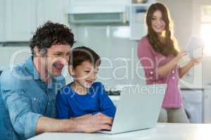 Family using digital tablet and laptop