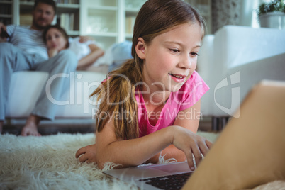Girl lying on the floor and using laptop