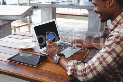 Man doing online shopping with credit card on laptop