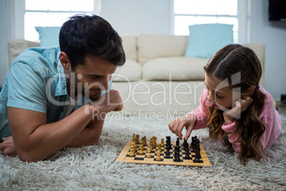 Father and daughter playing chess in the living room