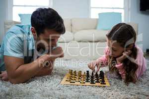 Father and daughter playing chess in the living room