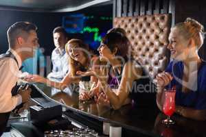 Beautiful woman interacting with waiter at bar counter