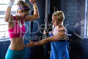 Female trainer instructing woman in gym
