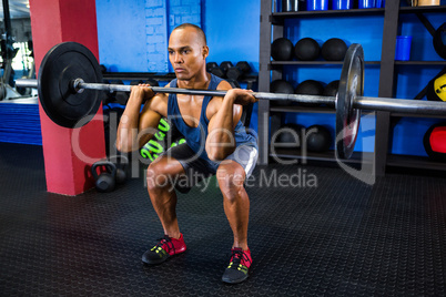 Male athlete weightlifting in fitness studio