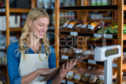 Smiling female staff looking at clipboard