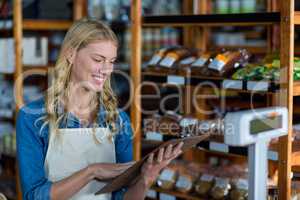Smiling female staff looking at clipboard