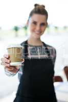 Portrait of smiling waitress offering coffee