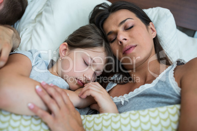 Mother and daughter sleeping together in bedroom
