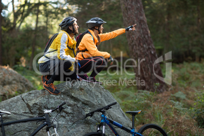 Biker couple sitting and pointing in distance