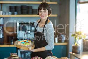 Portrait of waitress holding cup cake on tray in cafÃ?Â©