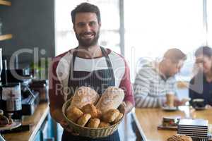 Portrait of waiter holding a basket of bread