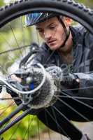 Male cyclist repairing his mountain bike