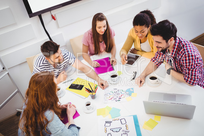 High angle view of business people discussing in meeting at creative office