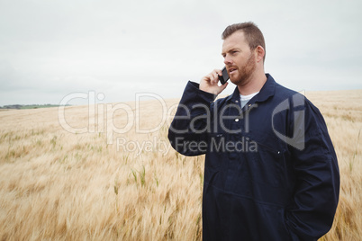 Farmer talking on mobile phone in the field