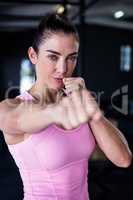 Portrait of confident female athlete punching