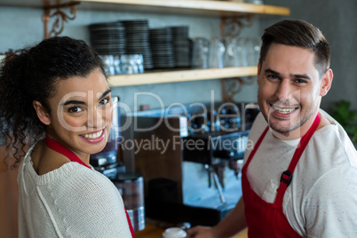 Smiling waitress and waiter in cafe