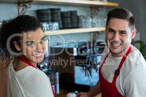 Smiling waitress and waiter in cafe