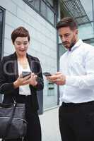 Businesspeople using mobile phone