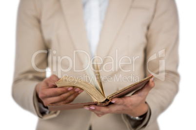 Mid section of Businesswoman flips through the pages of a book