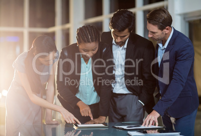 Group of businesspeople discussing together over digital tablet