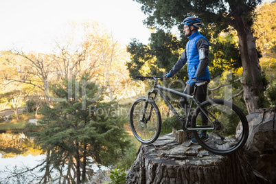 Male mountain biker with bicycle looking at nature