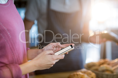 Woman using mobile phone in cafÃ?Â©