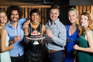 Woman holding birthday cake with her friends