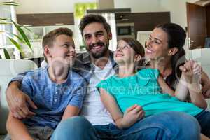 Happy family sitting with arm around on sofa