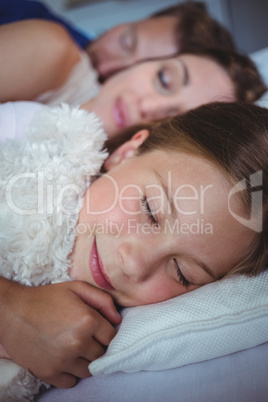 Family sleeping on bed