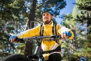Male mountain biker riding bicycle in the forest
