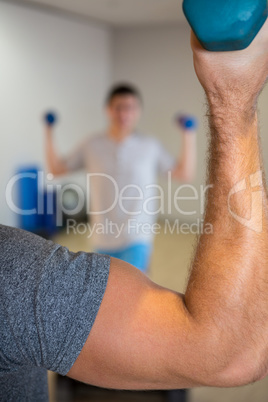 Close-up of mans hand lifting dumbbell