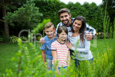 Happy family standing on grass in park on a sunny day