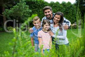 Happy family standing on grass in park on a sunny day