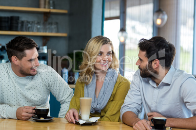 Friends interacting while have a cup of coffee