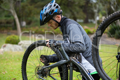 Male cyclist repairing his mountain bike