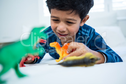 Boy playing with toys on bed