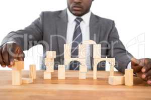 Businessman building tower of wooden blocks