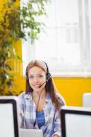 Portrait of confident businesswoman with headphones at creative office